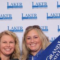 Two ladies holding up GVSU gear